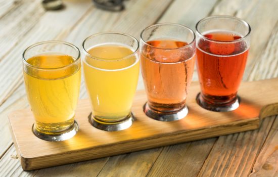 A flight of hard ciders a wooden flight paddle